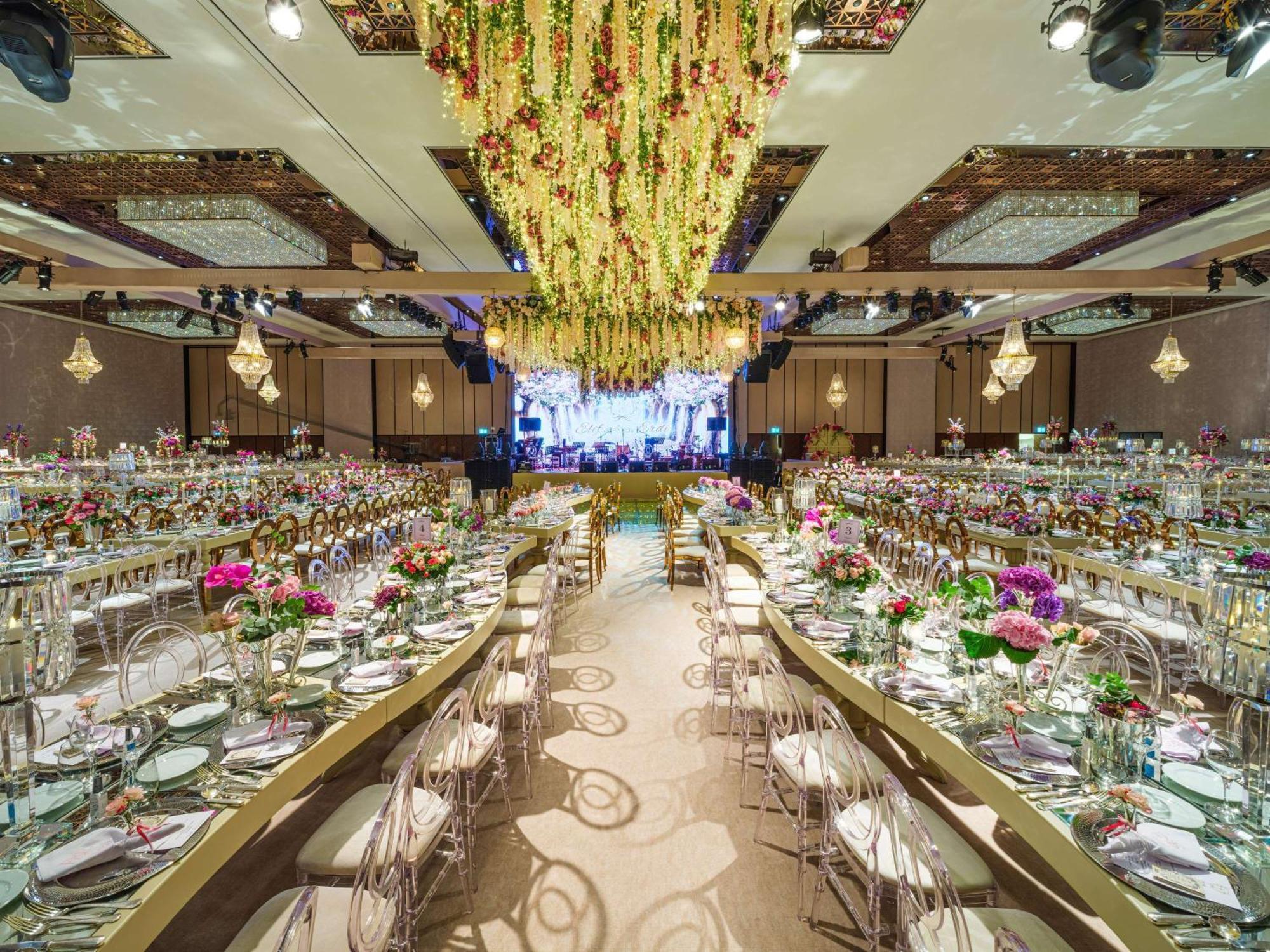 Swissotel The Bosphorus Istanbul Eksteriør billede The photo shows an elegantly decorated banquet hall set up for an event. There are long tables arranged in a U-shape, adorned with floral centerpieces and neatly set dinnerware. The decor features vibrant flowers in various colors. Above the tables, 