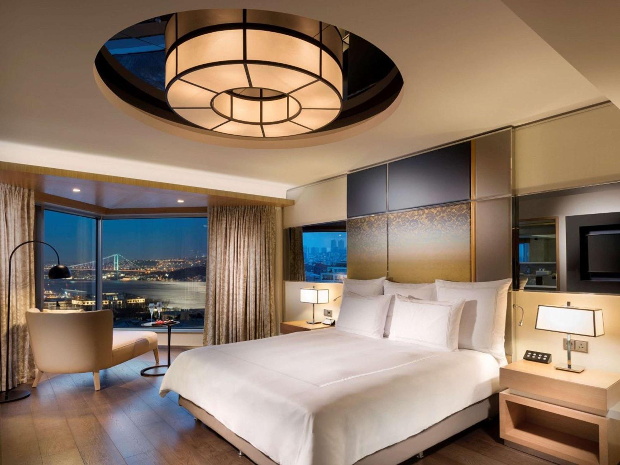 Swissotel The Bosphorus Istanbul Eksteriør billede The photo shows an upscale hotel room featuring a modern and stylish design. Central to the room is a large, neatly made bed with crisp white bedding. The walls are adorned with a blend of warm colors and textures, complemented by elegant lighting fi